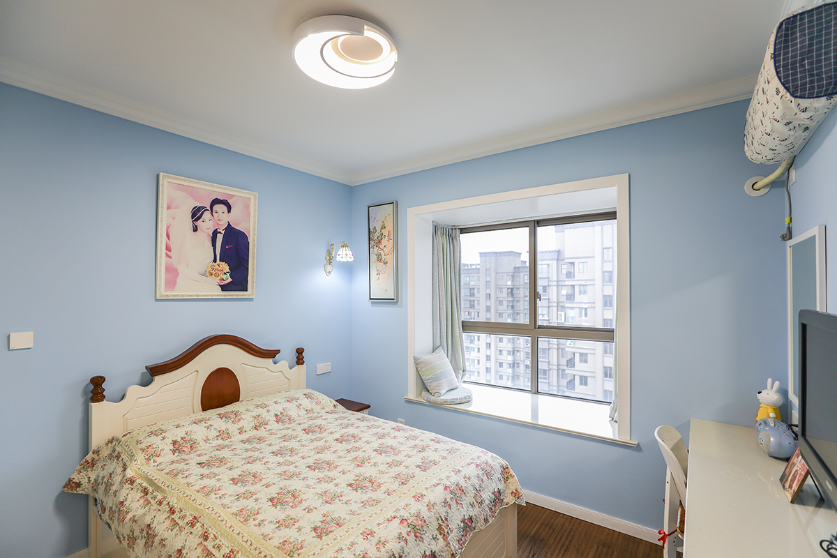 主臥墻面仍然是女主人最愛的藍色，配上地中海風格的木床和碎花床藝，加上深色地板，整個空間靜謐而美好。
