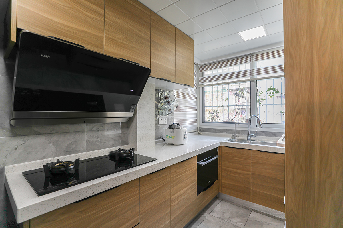     U型的廚房間，木飾面的柜門，金色的冰箱，灰色的墻地磚，讓廚房更加富有實用性、功能性，美學與使用的結合。更加讓空間具有輕奢的感覺。
