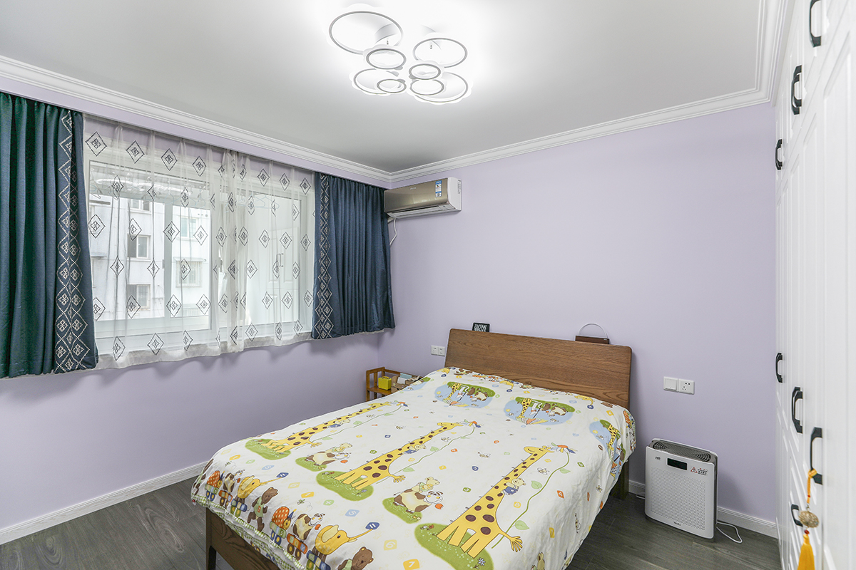 次臥為了區(qū)別于主臥，衣柜采用了簡潔而更現(xiàn)代的白色衣柜，與衣帽間形成呼應(yīng)。胡桃木色的床讓整個空間增添了幾分暖意。
