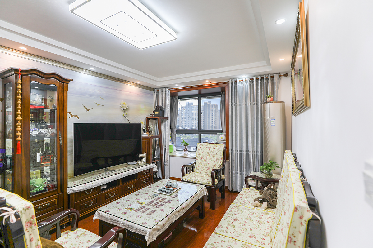 經典新中式風格的柚木家具，配以淺色墻面，小碎花的軟裝給以現代中式增添了一抹溫情，高低錯落的電視柜，更增加了空間的層次感
