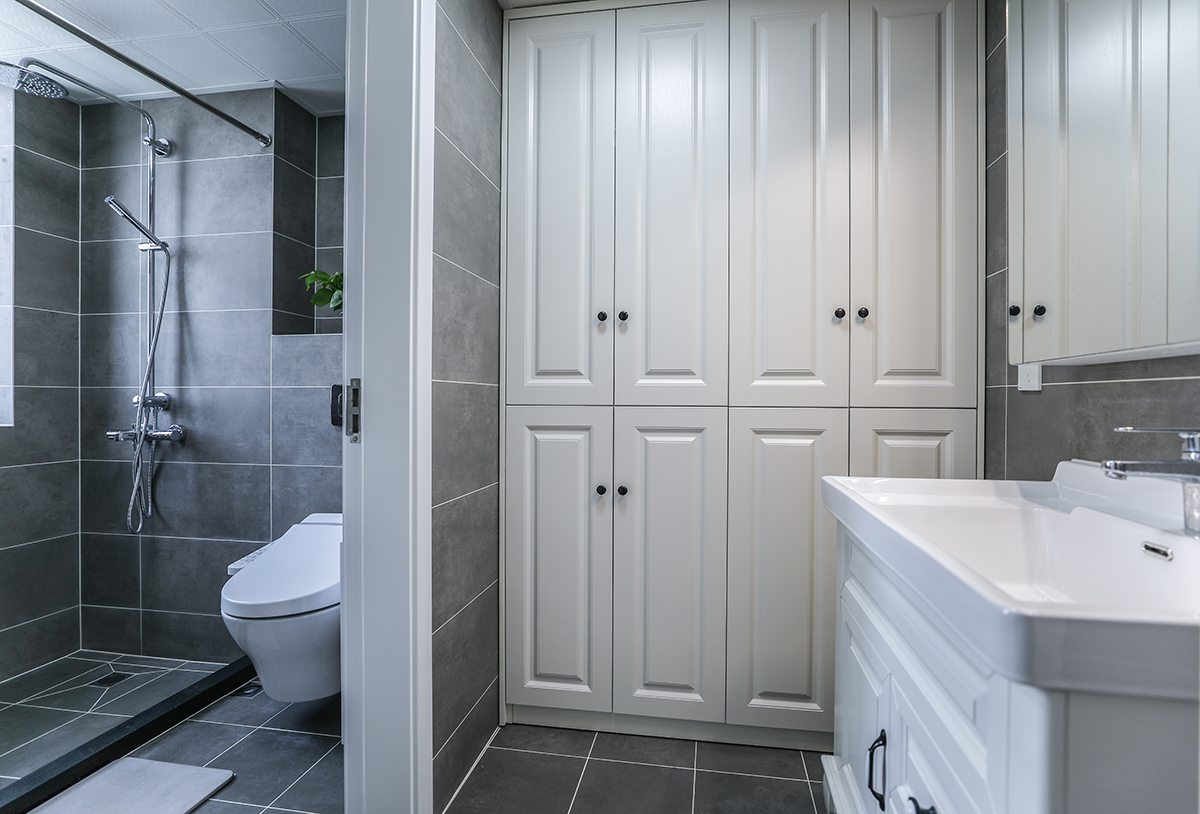 衛生間采用干濕分離，日常使用更加方便。干區除了臺盆柜，也根據主人的生活習慣，設計放置了一面儲物柜。灰色亞光仿古磚，與整體色調風格統一和諧。 
