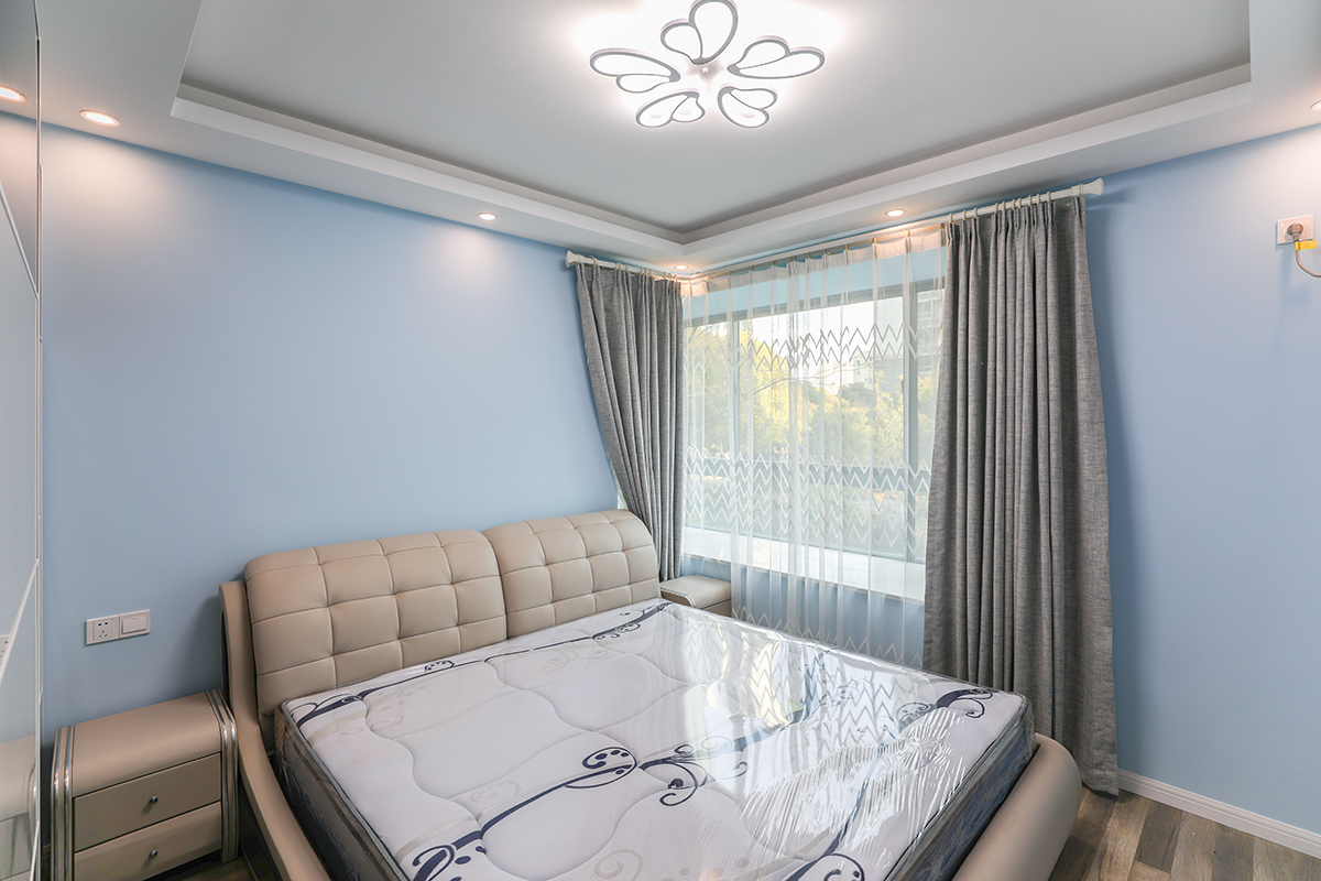 主臥室采用飄窗加以咖色的窗簾使得本身單調的色彩空間立馬體現出色彩的多樣話和柔和度，使得整體色彩非常的舒服，給人以非常舒服的休息環境，皮質的家具使得色彩反差非常的大，立體效果非常的舒服，體現業主的追求極簡自由的生活。
