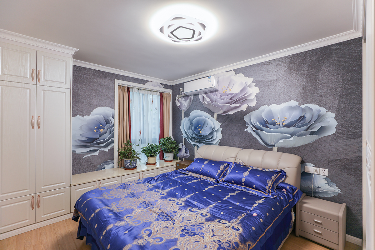 主臥大膽的使用了大花型的墻紙，整個房間貴氣又雅致，床邊上設計了一組高柜+飄窗柜的設計，大面積的增加了儲物的空間。
