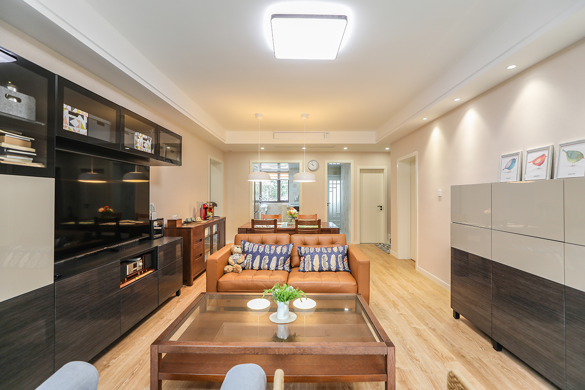 業(yè)主在選擇家具的時(shí)候，以簡(jiǎn)單的線條為準(zhǔn)。比如黑色的電視柜、咖啡色的沙發(fā)，還有一只書香氣息很重的藤椅，配上原木色地板，整體相結(jié)合。把家具的層次，空間的大小，整個(gè)客廳的色調(diào)井然有序，很有條理的處理好。原木色的桌椅，放在沙發(fā)背后，配上三個(gè)簡(jiǎn)潔的簡(jiǎn)約燈，整個(gè)空間顯得格外和諧。現(xiàn)代室內(nèi)家具、燈具和陳列品的從整體空間的設(shè)計(jì)主題開始。家具應(yīng)依據(jù)人體一定姿態(tài)下的肌肉、骨骼結(jié)構(gòu)來選擇、設(shè)計(jì)，從而調(diào)整人的體力損耗，減少肌肉的疲勞。燈光設(shè)計(jì)的發(fā)展方向主要有兩大特點(diǎn)：一是根據(jù)功能細(xì)分為照明燈光、背景燈光和藝術(shù)燈光三類，不同居室燈光效果應(yīng)為這三種類型的有機(jī)組合；二是燈光控制的智能化、模式化，也即控制方式由分開的開關(guān)發(fā)展為集中遙控，通過設(shè)定視聽、會(huì)客、餐飲、學(xué)習(xí)、睡眠等組合燈光模式來選擇最佳的效果。對(duì)于陳列品的設(shè)置上，應(yīng)盡量突出個(gè)性和美感。
