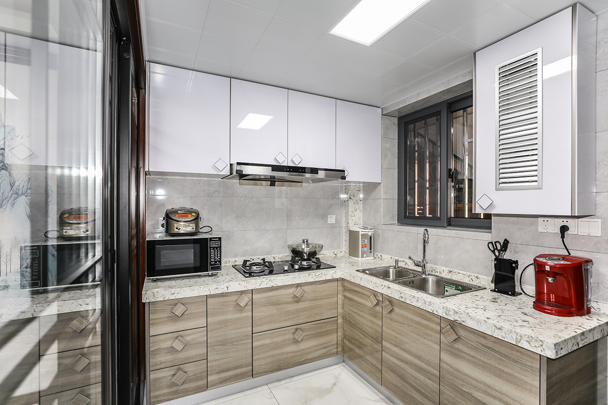 廚房磚面選擇了墻深地淺的磚面做背景，顛覆裝修的地深墻淺的傳統的概念同時，給與了廚房充分的采光的同時，呼應了櫥柜的下深上淺，色彩變換的同時增加了空間的層次感，廚房間四扇移門兩兩對應，呼應了中式中不變固有的對稱同時將陽光引入了室內.
