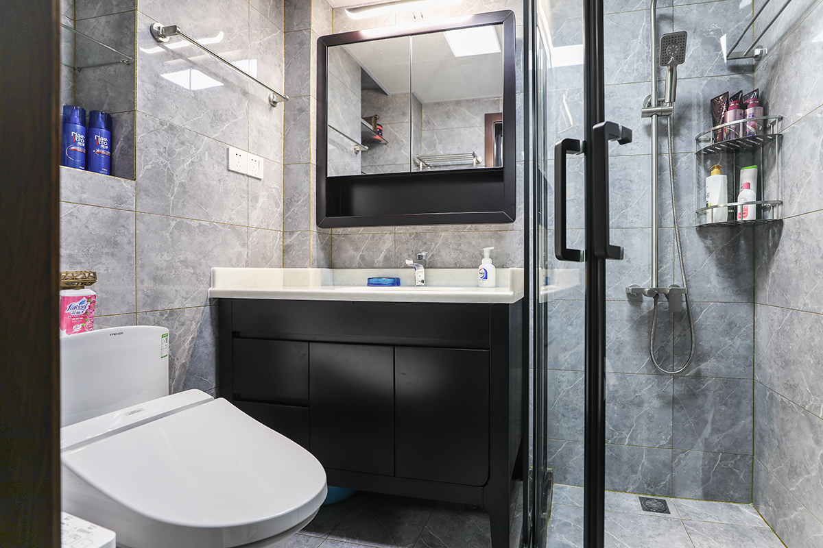 不大的衛生間，采用了深灰色的墻地磚，整體大磚將不大的衛生間保持了很好的整體性，深灰配以了黑色臺盆，凸顯了主人穩重的氣質和追求時尚的心
