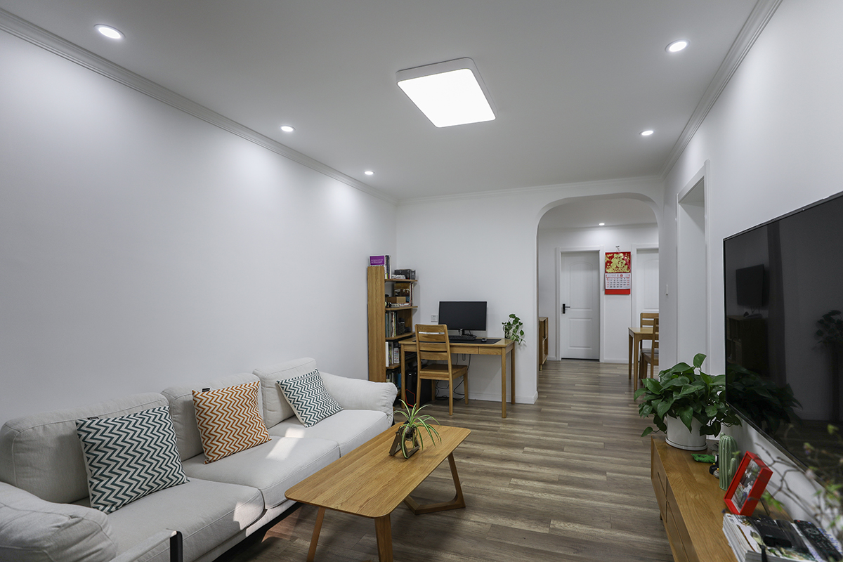 客廳仍然以白色為主色調(diào)，通過原木色的融入以及灰色的過渡，呈現(xiàn)簡潔明快的生活氣息，橢圓形拱門的設(shè)計增添了些許俏皮。
