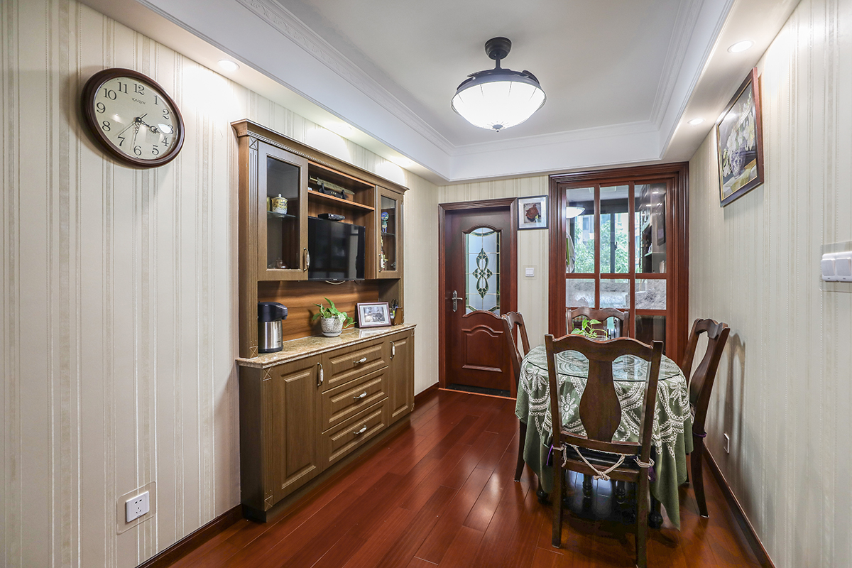 餐廳部分利用了原來門洞的空間做了一個餐邊柜，既美觀又實用且不占空間。由于風格較為簡約，家具一般選用胡桃木家具，這樣更能突出木質的本身特點，在不同角度上產生不同的光感。
