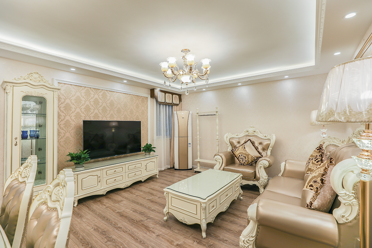 客廳的玻璃窗帶來了良好的采光，落地的窗簾很是氣派。布藝沙發(fā)組合有著絲絨的質(zhì)感以及流暢的木質(zhì)曲線，將傳統(tǒng)歐式家居的奢華與現(xiàn)代家居的實用性完美地結(jié)合。壁爐自然不可或缺，它被安置在空間結(jié)構(gòu)的交匯處，與一幅色彩鮮艷的油畫相呼應(yīng)，敞開式的客廳提供了一個視覺中心。
