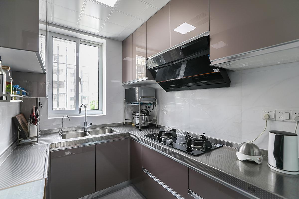 廚房是使用頻率最高的區(qū)域，不但要功能齊全，又要方便清潔好打理，所以材質(zhì)上采用金鋼門板，考濾臺(tái)面要經(jīng)久耐用，所以彩用不銹鋼臺(tái)面，配上白色大理石紋理墻磚、金色櫥柜門板。空間簡(jiǎn)潔、干凈，方便清理，色調(diào)上又不單一。
