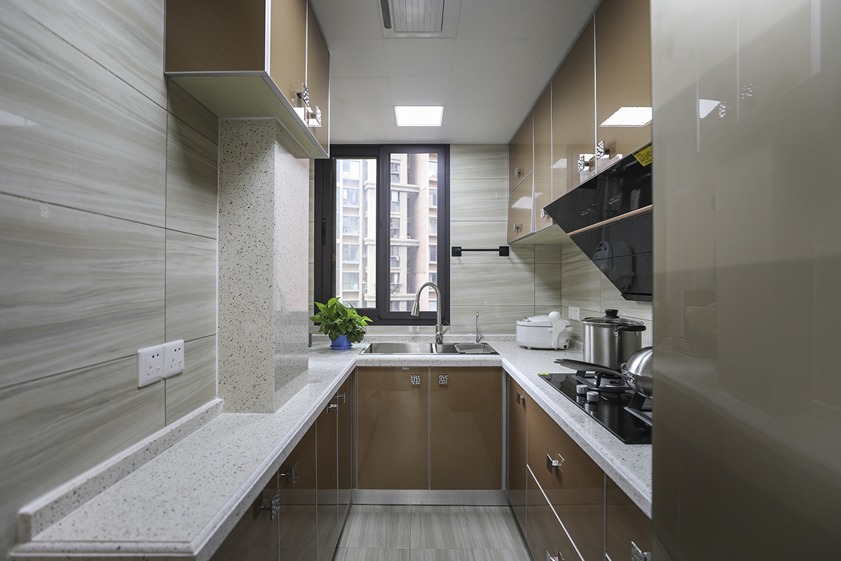 廚房設計成U形廚房，擴大了進門的視覺空間，又使得廚房的操作和儲物成倍的提升。墻磚選用木紋磚擴大整體的視覺。
