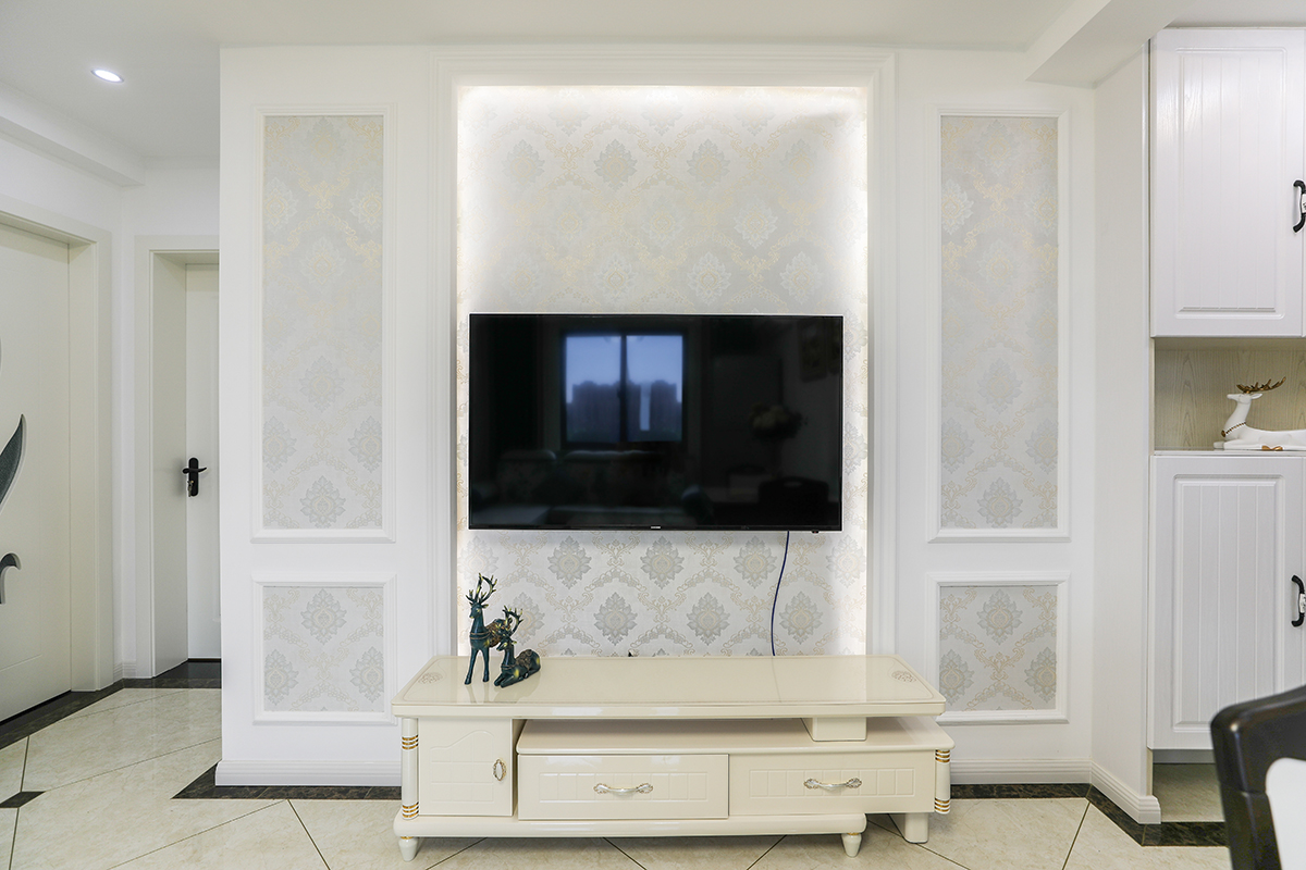 電視背景墻護墻板墻布的搭配，燈帶的點綴增加了背景墻的層次，讓客廳更加豐富，空間飽滿。入戶玄關柜子功能性強，換鞋凳，掛衣服去，裝飾柜，讓玄關成為入戶一景，同時方便了出入。
