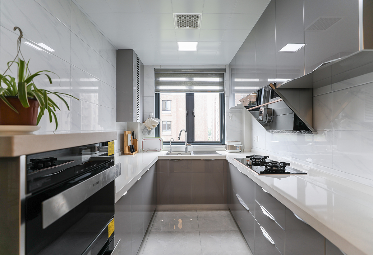 廚房采用灰色色系，充分體現(xiàn)簡約風(fēng)格，側(cè)吸的煙機(jī)，不銹鋼臺面和灰藍(lán)色櫥柜的合理搭配，顯現(xiàn)出客戶的整潔生活，灰色和白色瓷磚的搭配更加的合理大氣，隨著家庭電器的不斷增加使得廚房在設(shè)計上對于電器的需求充分合理的安排。
