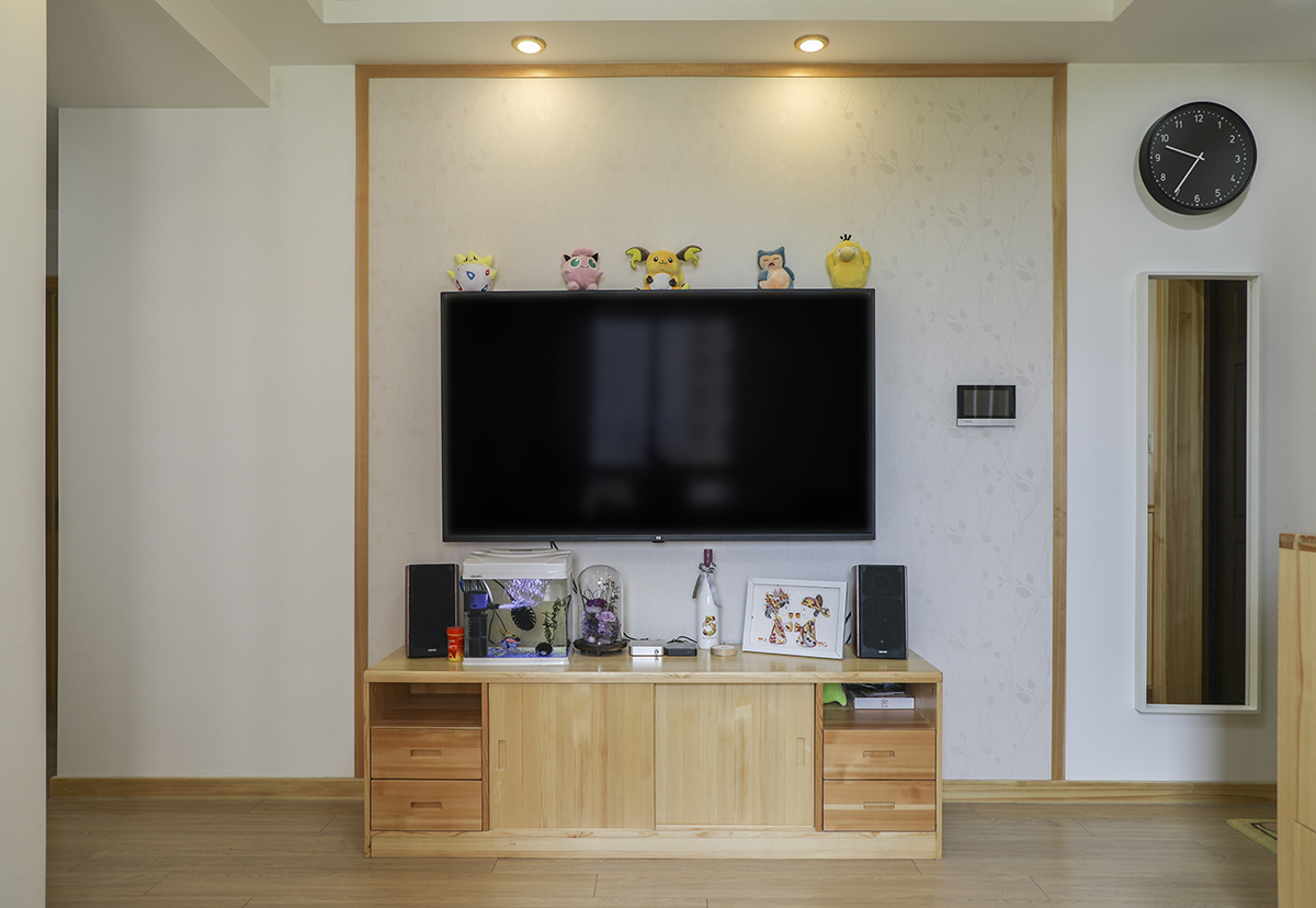 簡單的線條，淺色的墻布勾勒出簡約的背景背景墻，配合原木的電視柜突出整體風(fēng)格的主題
