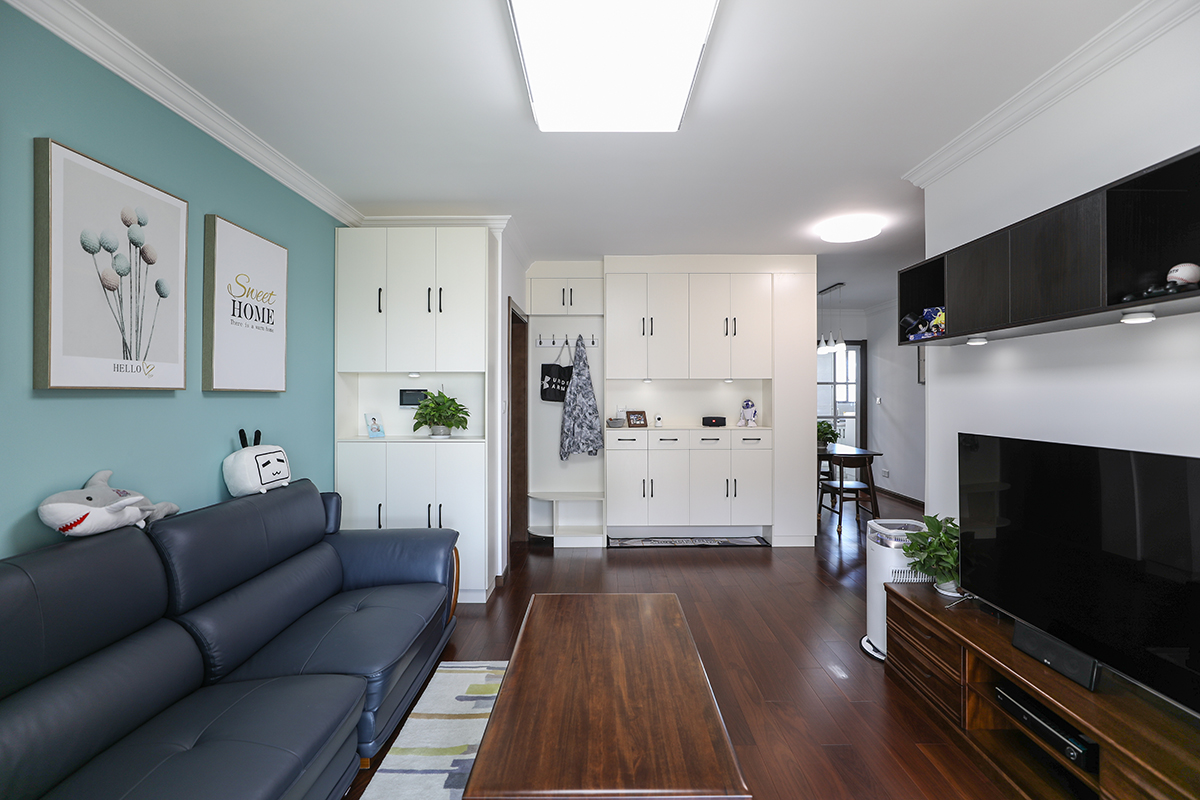  客廳：色彩上運用時下最流行的冷色調與原木結合，又有現代時尚流行的高級灰沙發的遙相呼應，給空間上帶來了視覺上的超強層次感。
