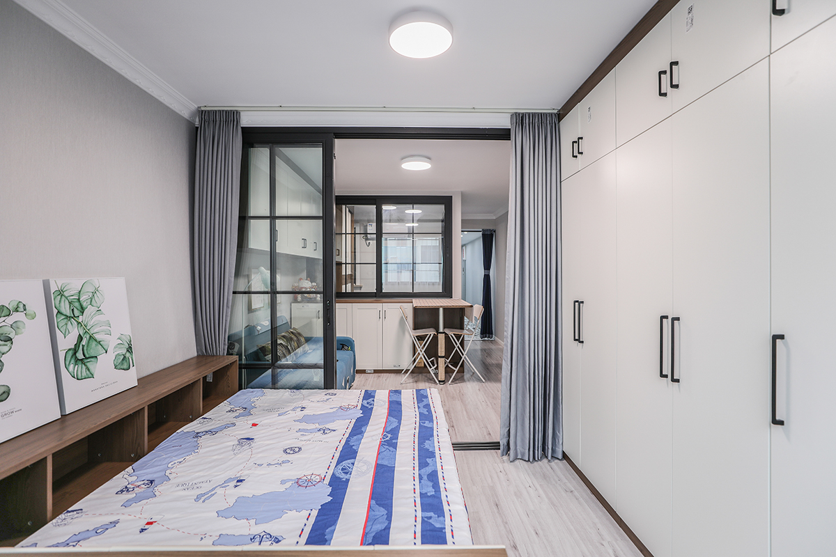 臥室的空間利用做了榻榻米式的床，既滿足空間小儲物充分利用，又滿足一個臥室床的需求，整面墻做了整體衣柜，可以放大量的衣物和物品。
