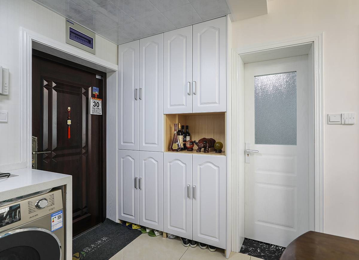 入戶過道處的進門鞋柜，巧妙的借用了原本衛生間的墻體，實用的同時也考慮了美觀。