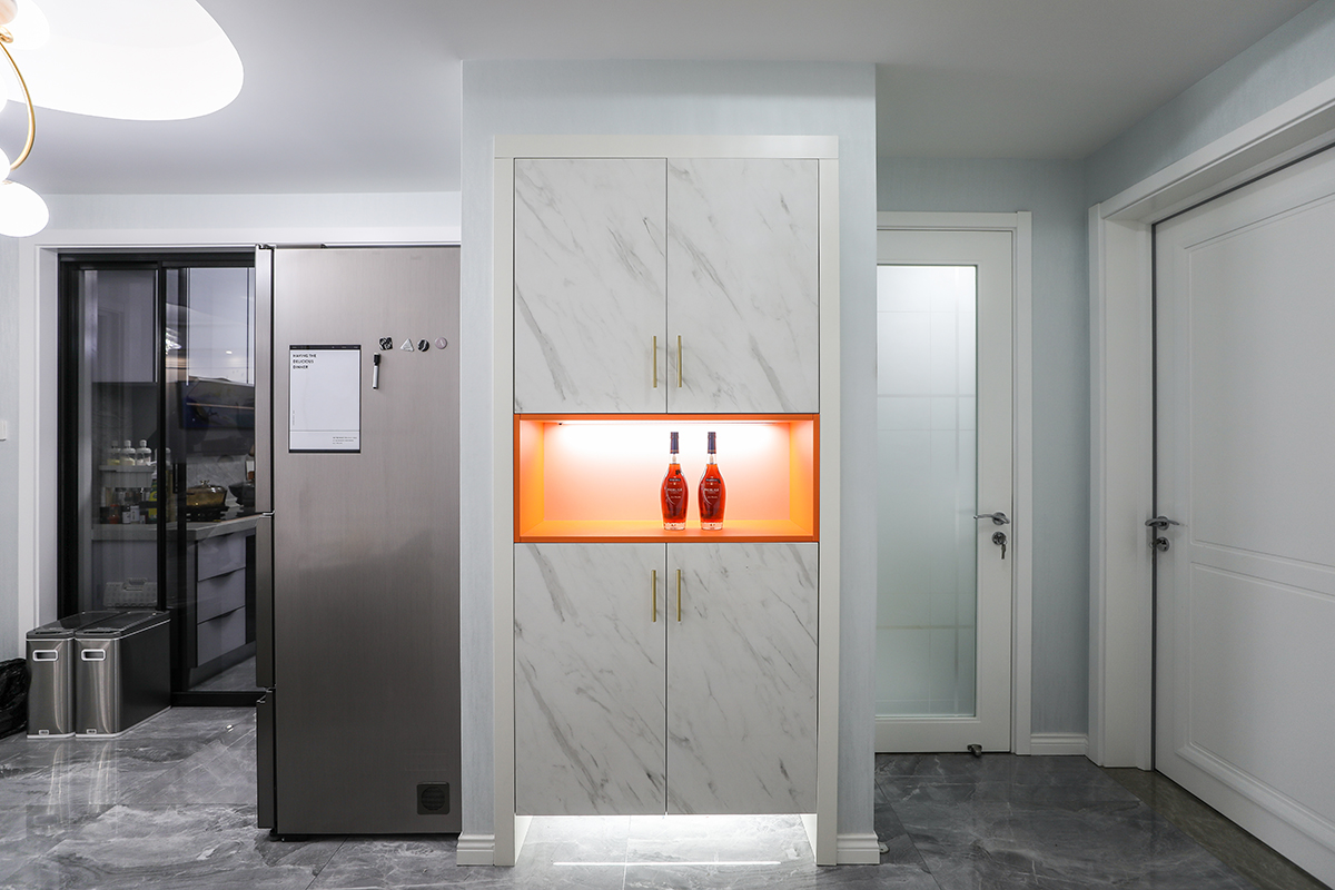 玄關(guān)采用灰色的地磚，配上仿大理石的鞋柜，配上有金屬線條的拉手，中間采用調(diào)色的鏤空色，讓真?zhèn)€鞋柜和客廳的背景的電大路大理石和檸檬黃調(diào)色的窗簾盒抱枕，讓整個空間更有層次感，從客廳貫穿餐廳到進門的門廳，動線和色彩都很明顯。