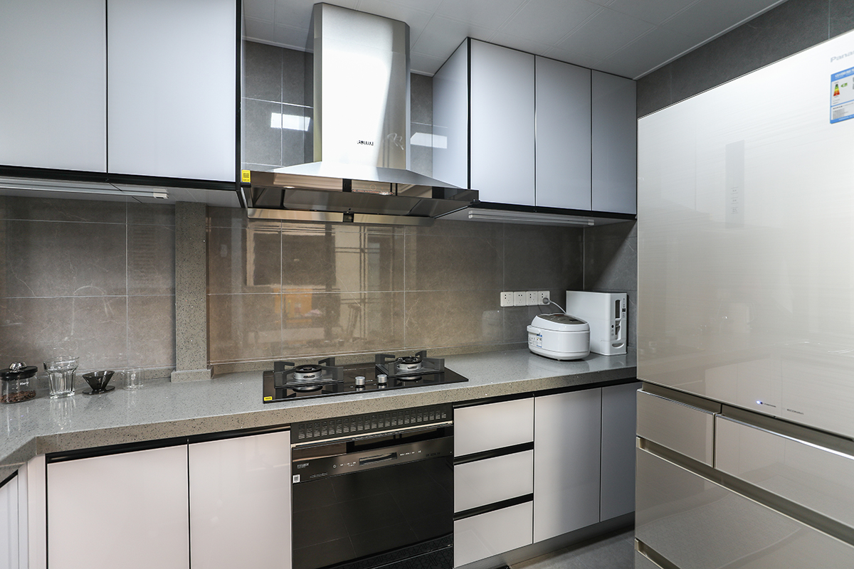 　該套房子廚房空間很大，蒸箱、烤箱等廚房電器一應俱全，能滿足主人對各種美食的制作需求。顏色要簡潔明快，材質要干凈和好打理，白色的吊頂、白色帶紋理的墻磚相呼應，白色的櫥柜門板。給人干凈、清爽、大氣華貴的感覺。
