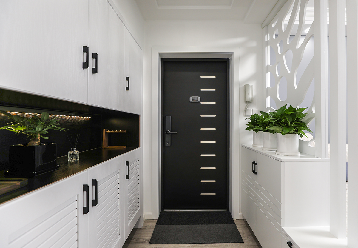 本套房子的玄關設計是一大亮點，左邊是儲物功能的衣帽柜，右邊造型柜，一方面具有換鞋蹬的功能，另一方面又具有屏風隔斷的功能，白色的實木造型屏風會讓人眼前一亮，一下子使整個空間活躍起來了。