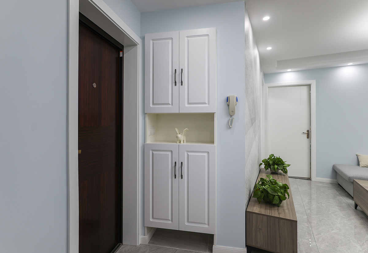 進門設計了玄關區域，嵌入式鞋柜既節約了空間，又保證了整體的美觀實用。