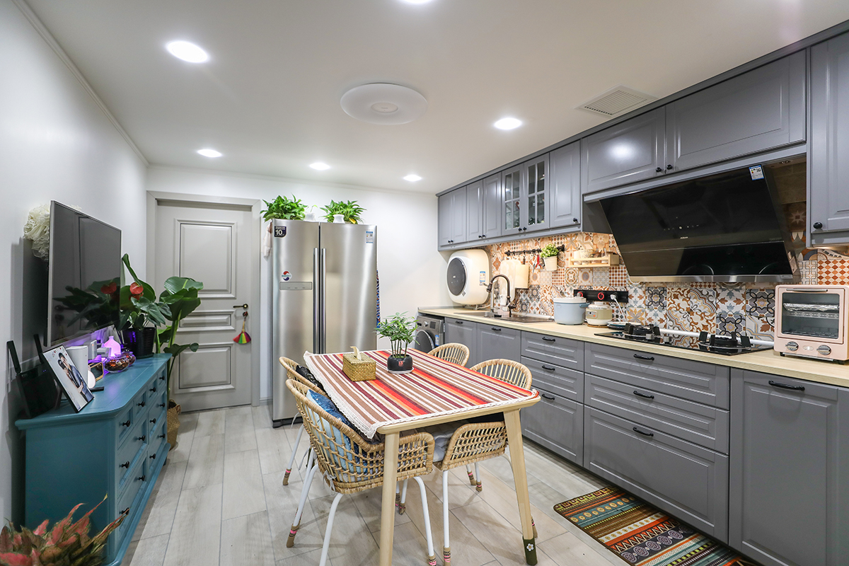 客餐廳地面選用地板磚，因為集合廚房區域，所以選用的是寬片地板磚。顏色需用淺灰，灰色百搭同時不會顯得空間過暗。電視柜選用了成品五斗柜集合了儲物及裝飾的功能。餐桌配以條紋桌布，色彩上與五斗櫥形成對比色。
