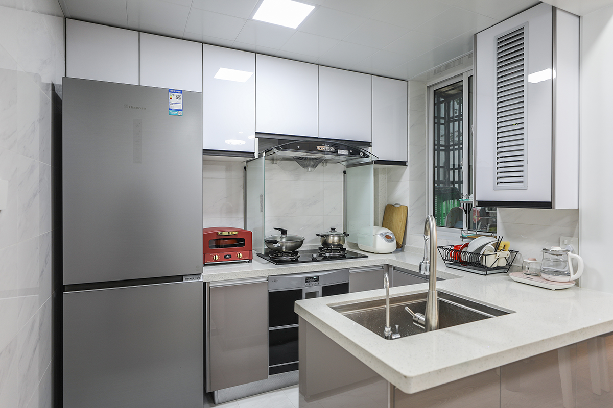 廚房做成了敞開式，因為空間不是特別寬裕，所以冰箱也都做成了嵌入式儲存功能更強(qiáng)，也使得空間變得整體，U字型的半開放設(shè)計令人感覺更大氣。
