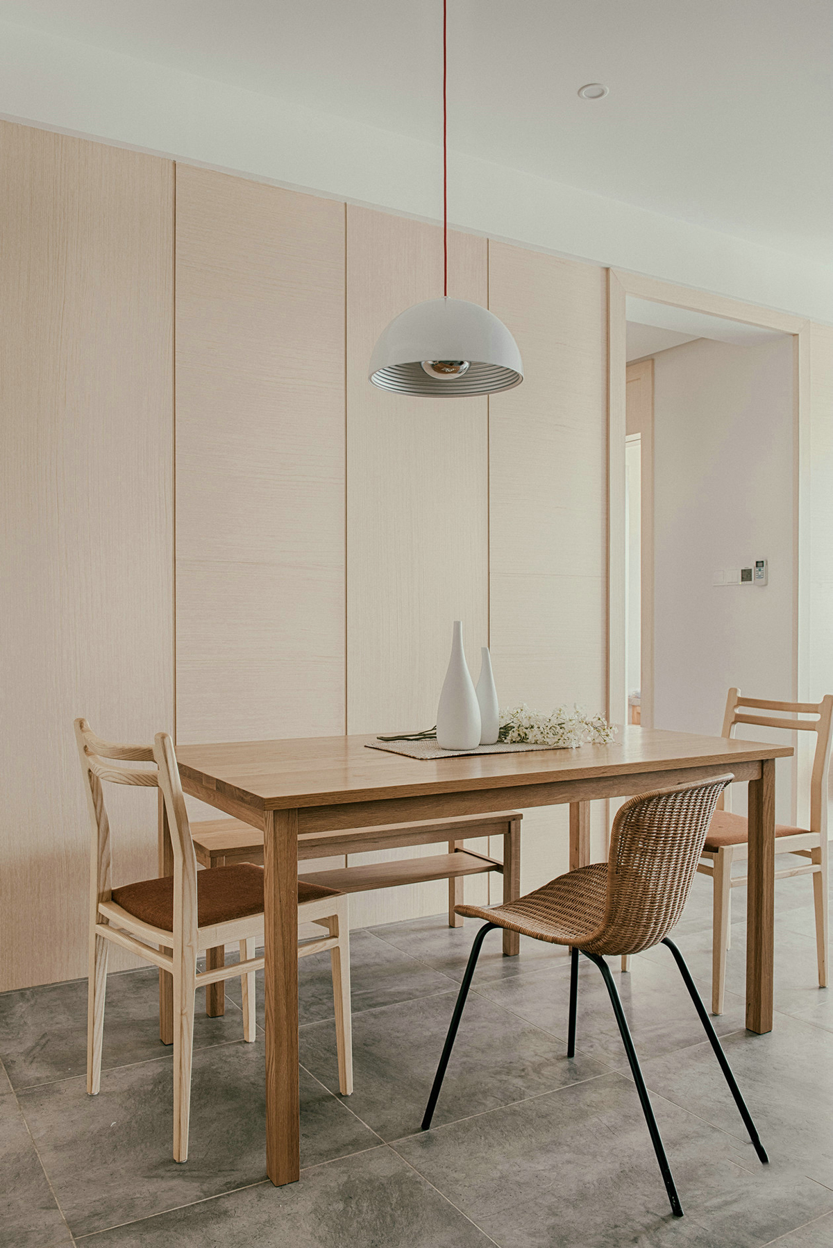 餐廳選用大面積淺系原木作為背景墻，與餐桌餐椅的材質顏色達到了統一，搭配十分和諧，原木色貫穿空間，日式原木氣息干凈又清新。
