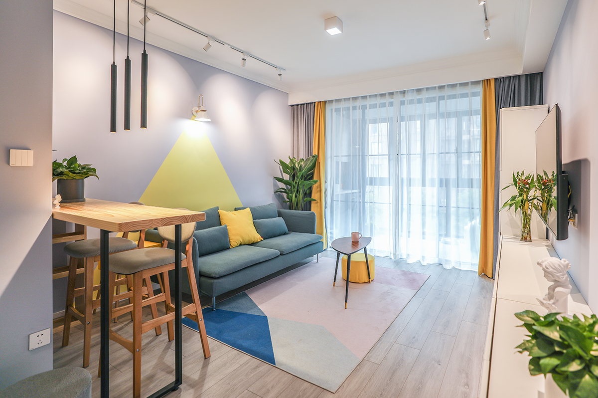 客廳背景墻采用乳膠漆的拼色來銜接，沒有使用軟包或者硬包，使得背景墻與整個(gè)空間能夠融合并且用幾何形的顏色塊來體現(xiàn)電視背景墻的突出性
