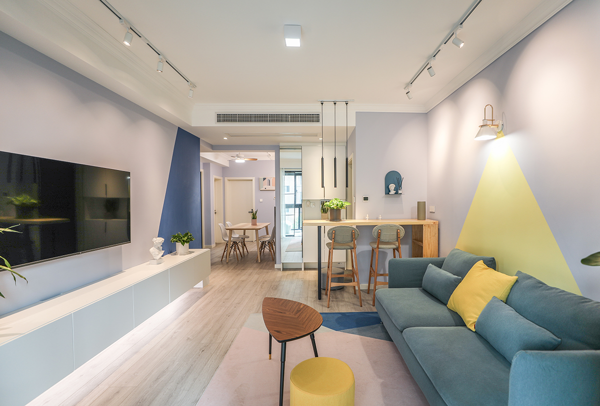 客廳背景墻采用乳膠漆的拼色來銜接，沒有使用軟包或者硬包，使得背景墻與整個(gè)空間能夠融合并且用幾何形的顏色塊來體現(xiàn)電視背景墻的突出性
