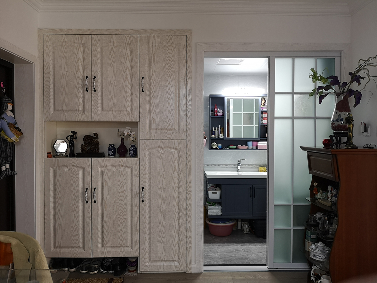 衛生間瓷磚選擇上也是灰色為主，大氣且時尚。進門做了鞋柜，方便了主人回到家換鞋的需求，上面放上了主人珍藏的擺飾，美觀而使用。