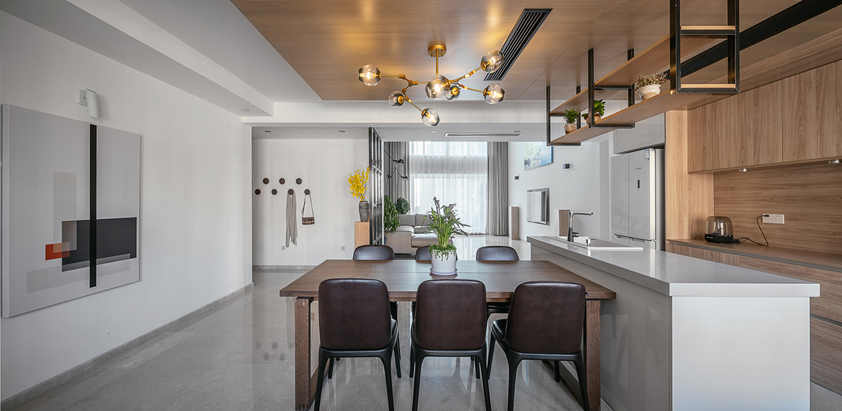 木飾面是貫穿整個空間的，顏色層次是黑白灰+木色的基調。大面積白色會使空間沒有很冷，所以用木色的溫潤來調節整個空間溫度。讓家的感覺更溫馨。櫥柜與頂面不是一家生產，在施工中先確定了櫥柜顏色。帶著樣板去定制頂面顏色，整體效果基本一致。櫥柜和吧臺的位置就是原來的空中花園，打通后空間開闊，可以和客廳統一。為了配合整體簡潔干凈的感覺，窗簾我選用木色百葉窗。透光和隱私性和布藝窗簾同等。右側的廚房是紅橡制作，為了保證實木的本質只做了清漆。顏色質感是市場銷售產品所達不到的。
